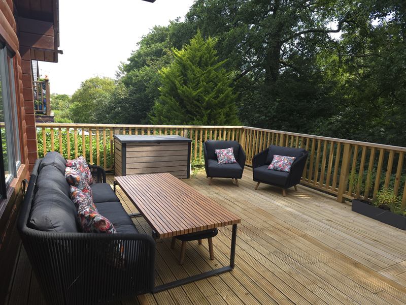 The deck, with outdoor seating and a long table under the trees