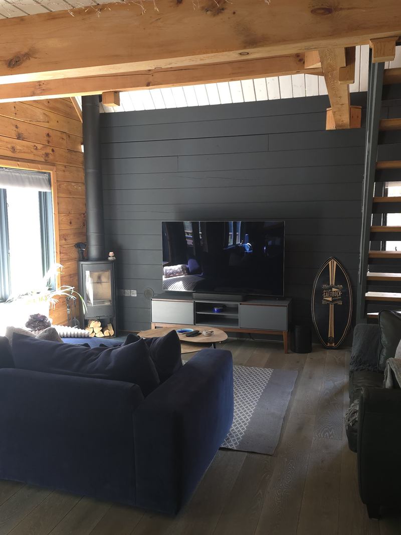 The open-plan living space, with the wood burner and the stairs to the top floor
