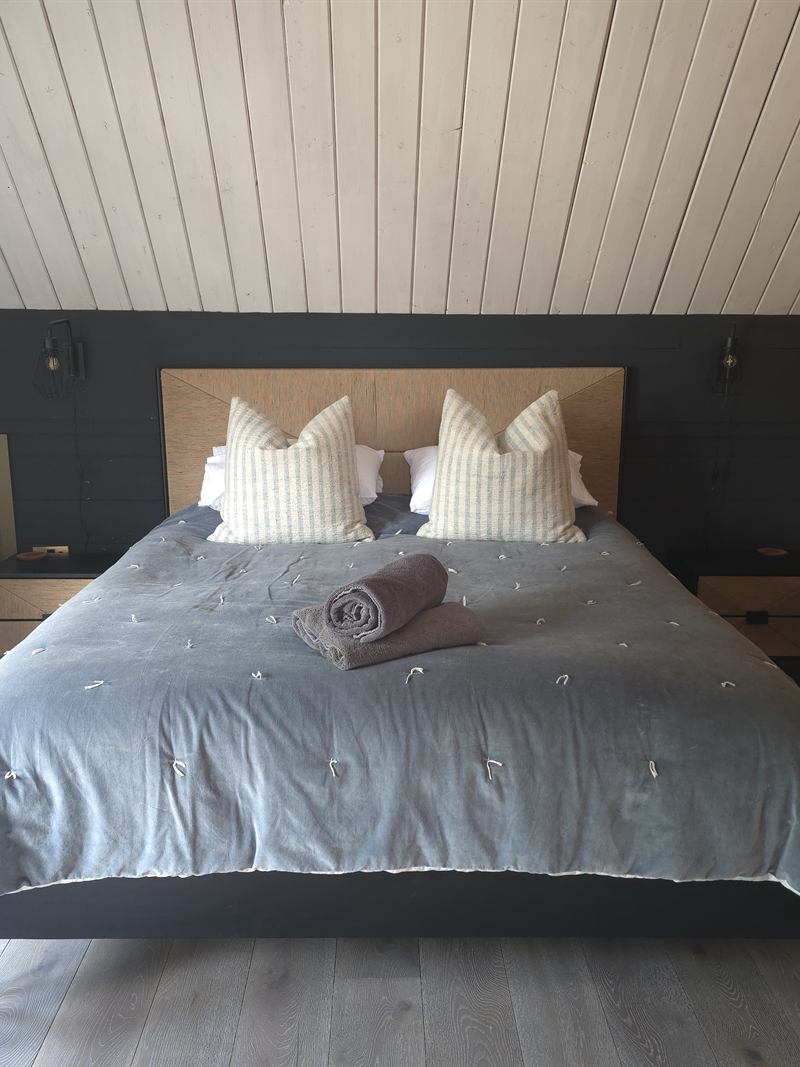 The master suite on the top floor, with a super king bed under the vaulted ceiling